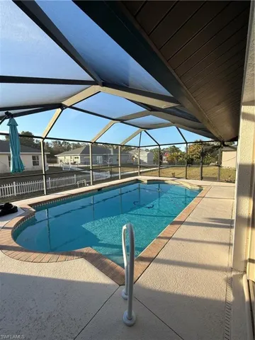 Swimming pool featuring a patio, a sunroom, a lanai, and a residential view