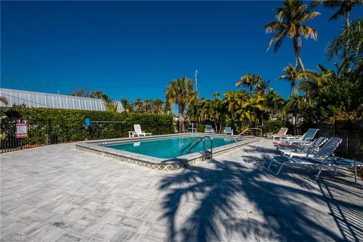 Community pool featuring a patio area and fence