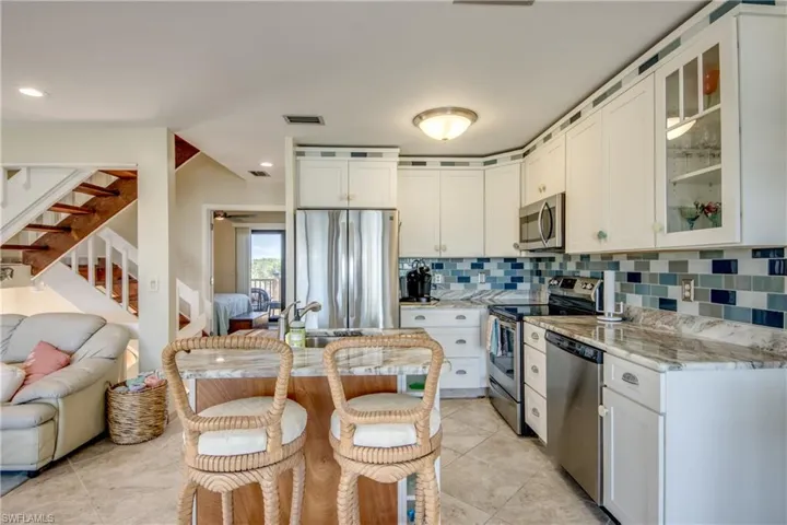 Kitchen featuring visible vents, stainless steel appliances, decorative backsplash, and open floor plan