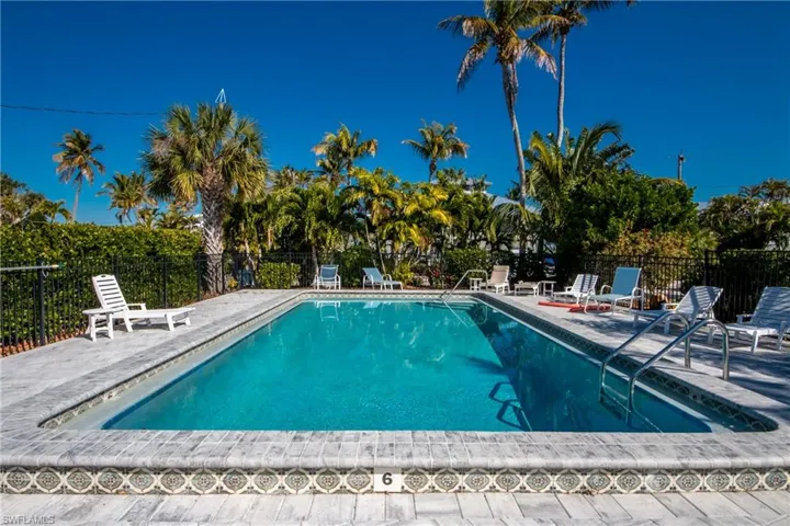 Community pool featuring a patio area and fence