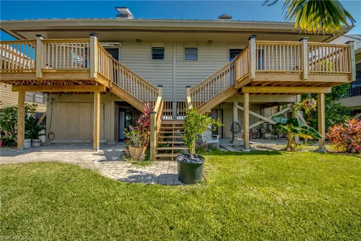 Rear view of property with stairway, a deck, a patio, and a yard