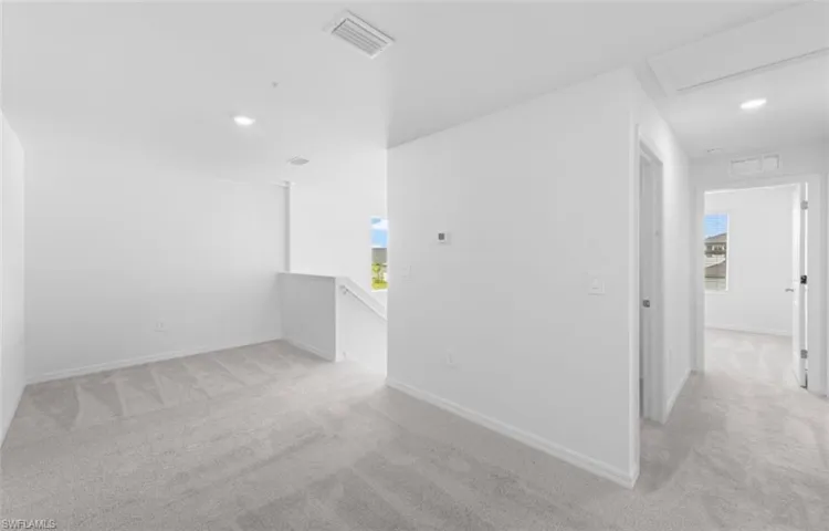 Spacious upstairs loft area with plush carpeting, recessed lighting and an open layout that offers endless possibilities as a home office, playroom or additional living space.
