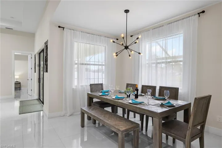 Dining room featuring light tile patterned floors, a notable chandelier, and plenty of natural light