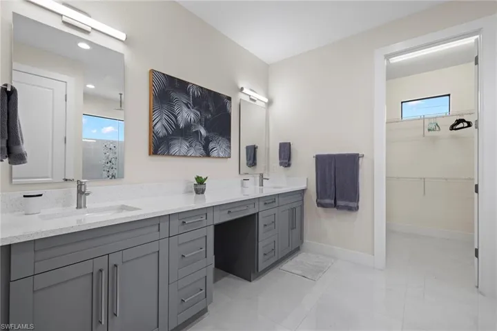 Bathroom featuring a shower with door, tile patterned flooring, and vanity