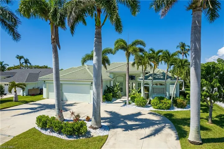 View of front of home with an attached garage, concrete driveway, a front lawn, and stucco siding