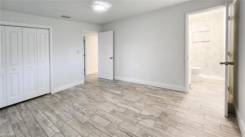 Unfurnished bedroom featuring light wood-type flooring and a closet