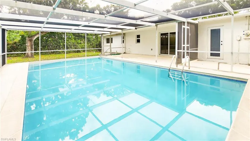 Swimming pool with a sunroom, a patio, and a lanai