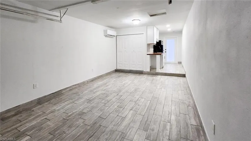 Unfurnished room with wood finish floors and a mini split for heating / cooling