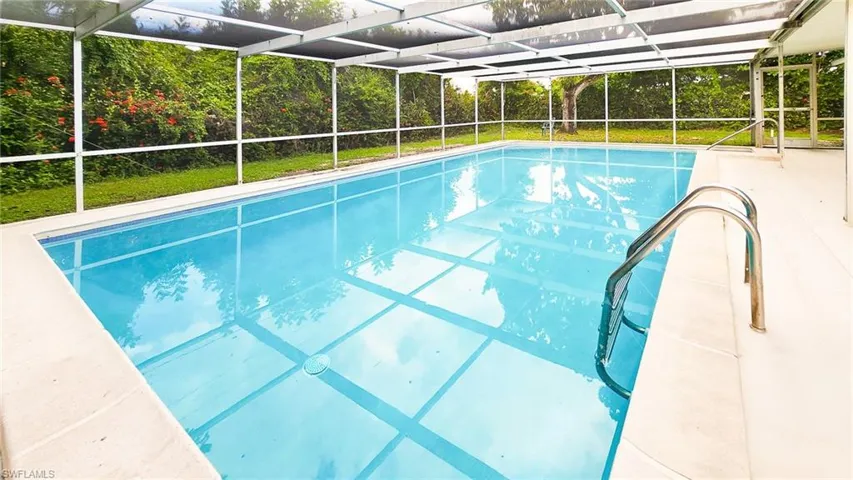 Swimming pool featuring a lanai, a sunroom, and a patio area