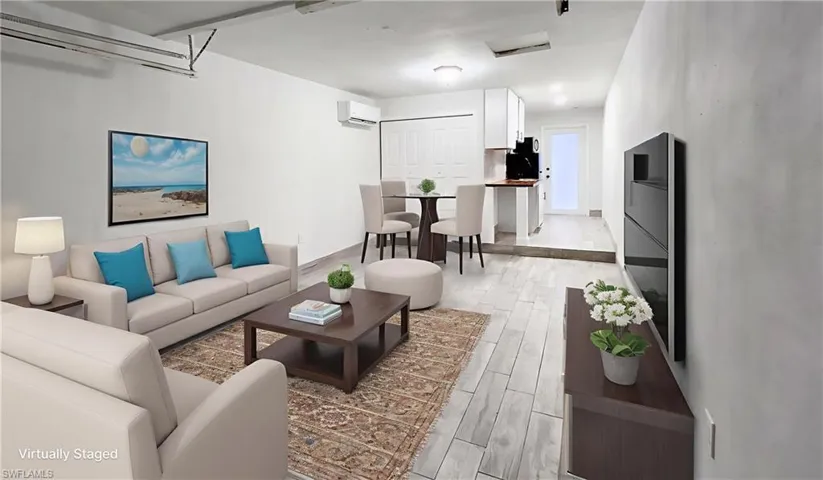 Living room with light wood-type flooring and a wall mounted mini split