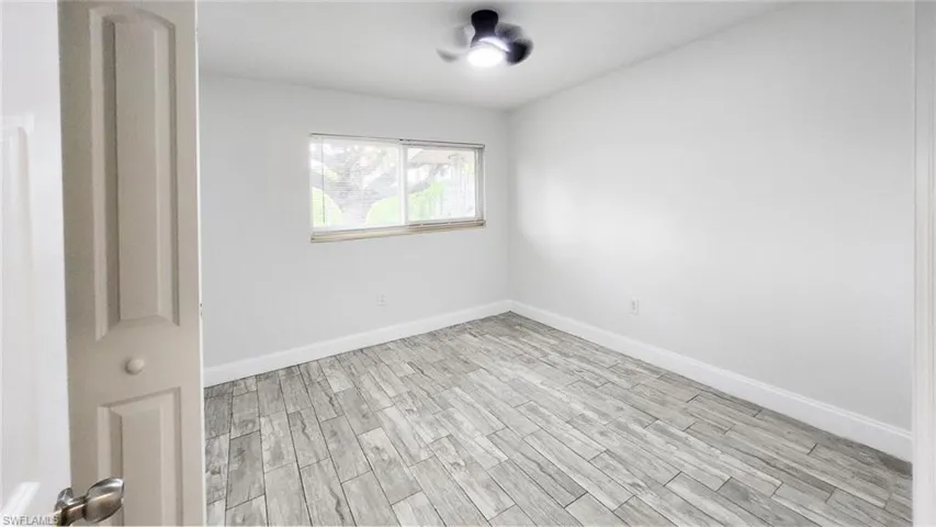 Spare room featuring wood tiled floors and baseboards