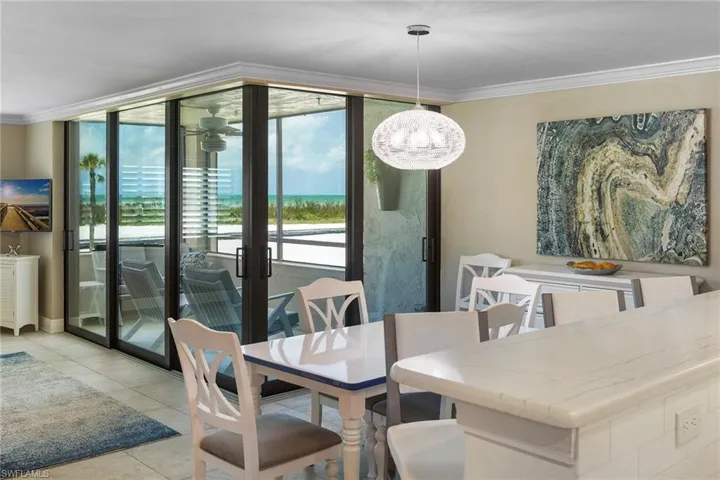 Dining room featuring crown molding, light tile patterned floors, and expansive windows