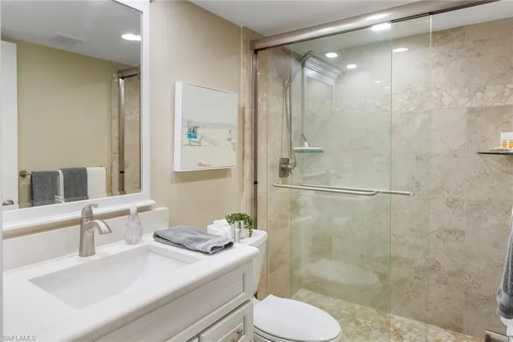 Full bathroom with vanity, toilet, a stall shower, and recessed lighting