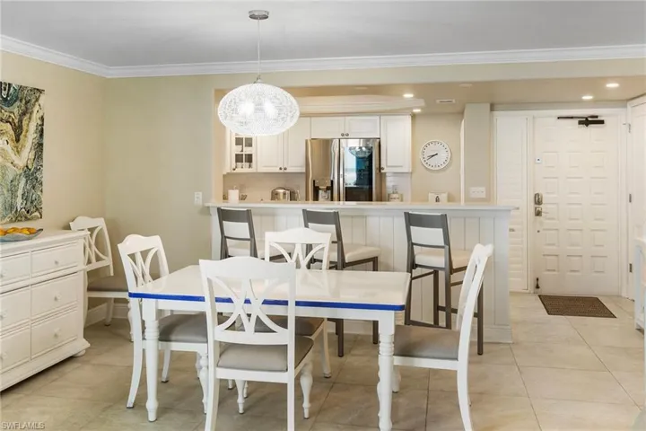 Dining space featuring crown molding, light tile patterned floors, baseboards, and recessed lighting