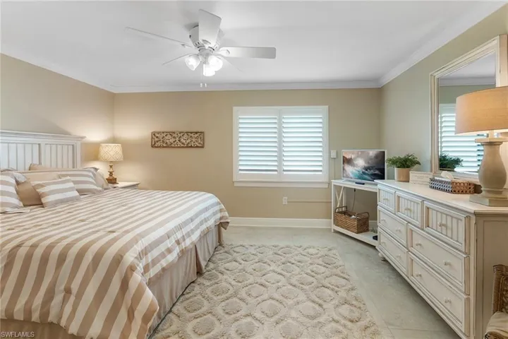 Bedroom featuring crown molding, a ceiling fan, light tile patterned flooring, and baseboards