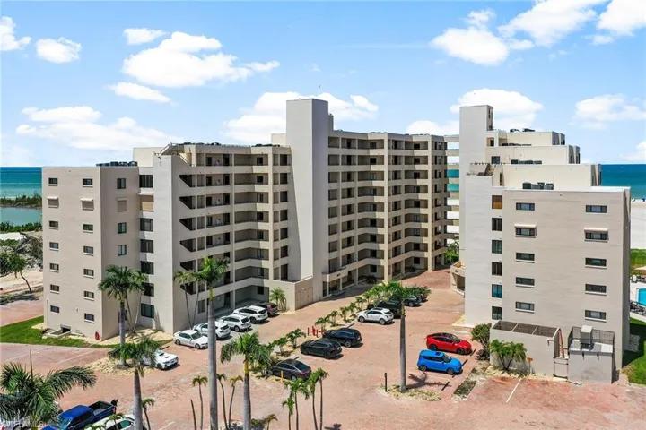 View of apartment building / complex with uncovered parking and a water view