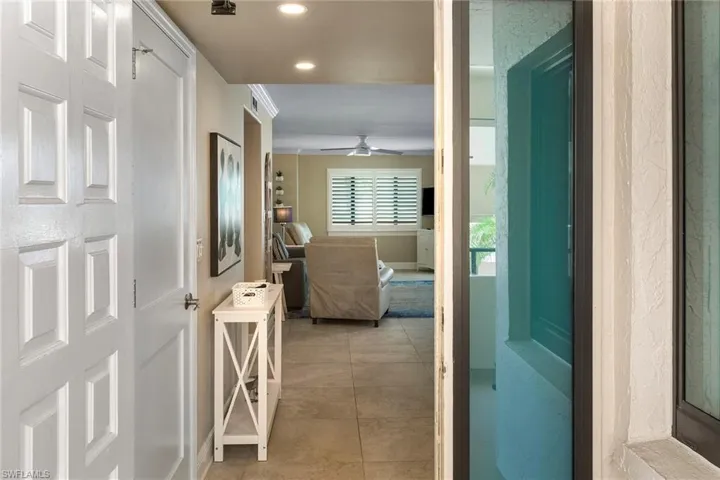 Corridor with recessed lighting, light tile patterned floors, and baseboards