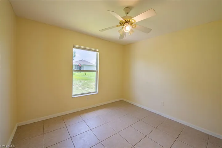 Interior room featuring tile flooring, a window with horizontal blinds, a ceiling fan with integrated lighting, and painted walls with white baseboards