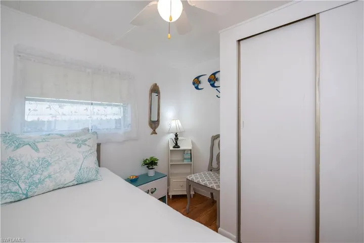 Bedroom featuring ceiling fan, dark wood-type flooring, and a closet