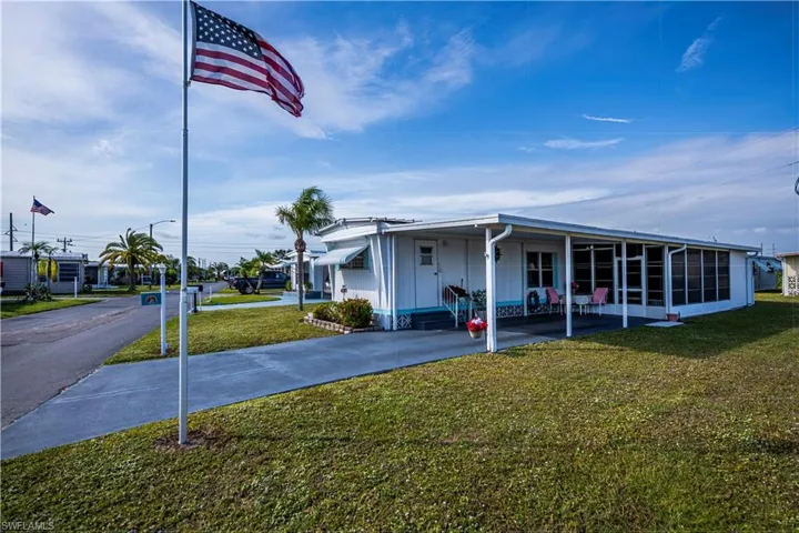 View of front facade featuring a sunroom and a front lawn