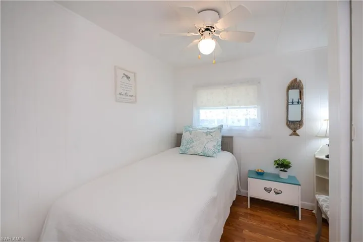 Bedroom with ceiling fan and dark wood-type flooring