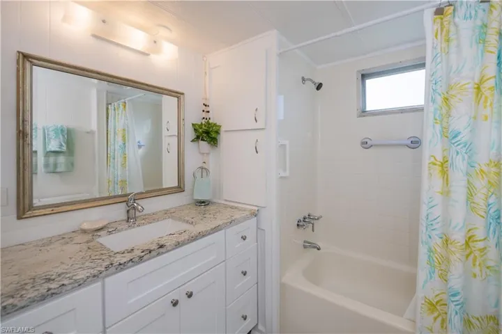 Bathroom with vanity and shower / tub combo with curtain