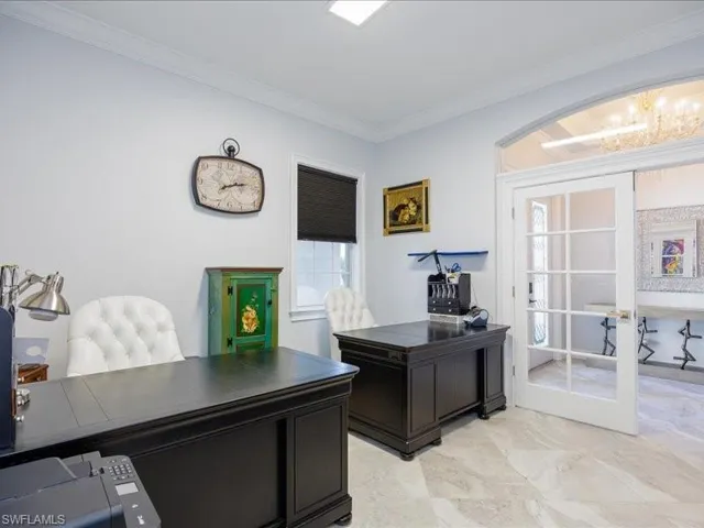 Room featuring light-toned walls, crown molding, and large format tile flooring