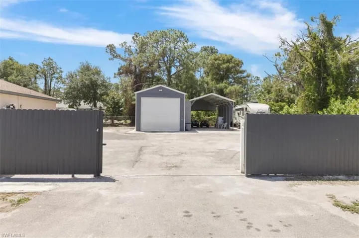 Detached garage featuring fence and a detached carport