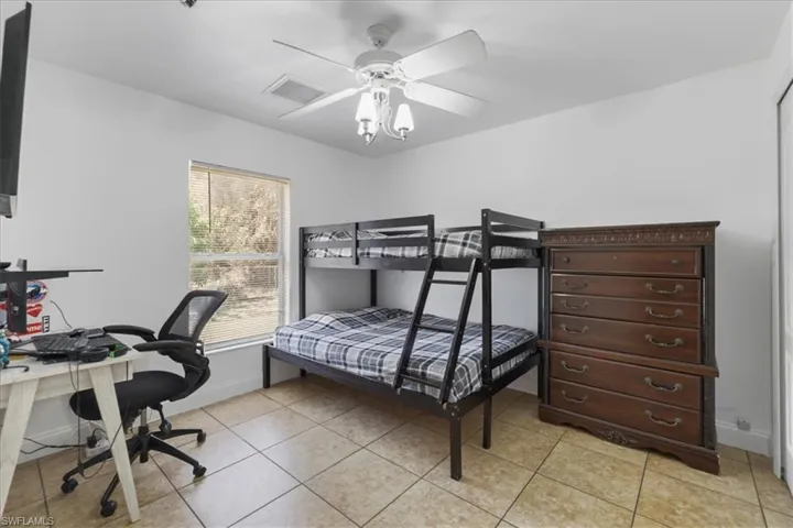 Bedroom featuring baseboards, visible vents, a ceiling fan, and light tile patterned flooring
