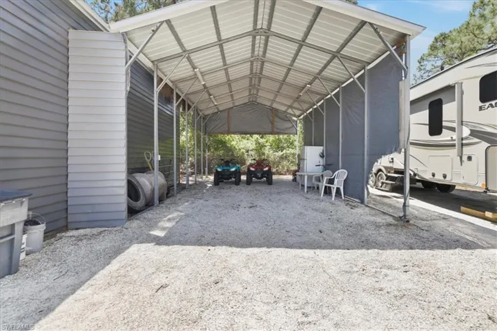 View of car parking featuring driveway and a detached carport