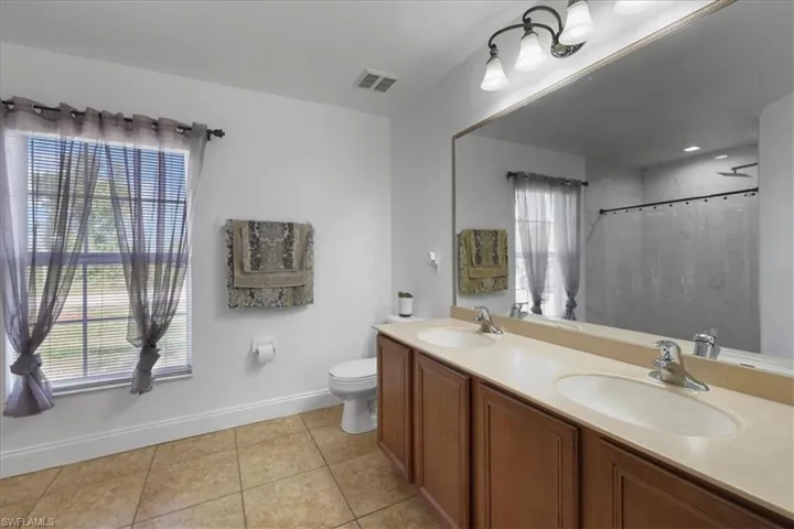 Bathroom with baseboards, tile patterned flooring, and a sink