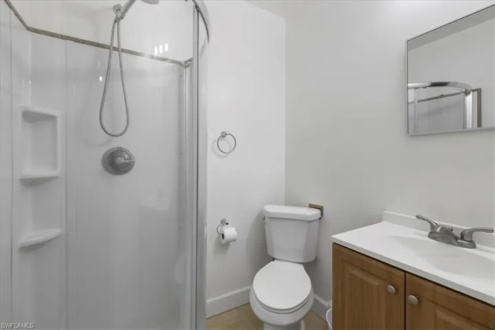 Full bath with a shower stall, toilet, and vanity