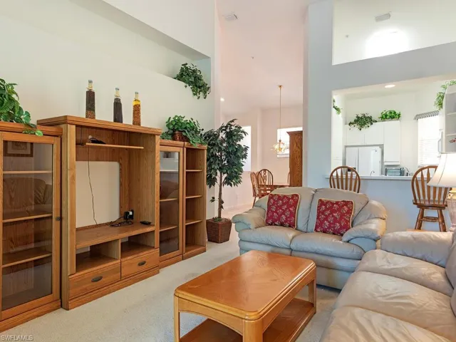 Living room featuring a high ceiling, carpet flooring, and a chandelier