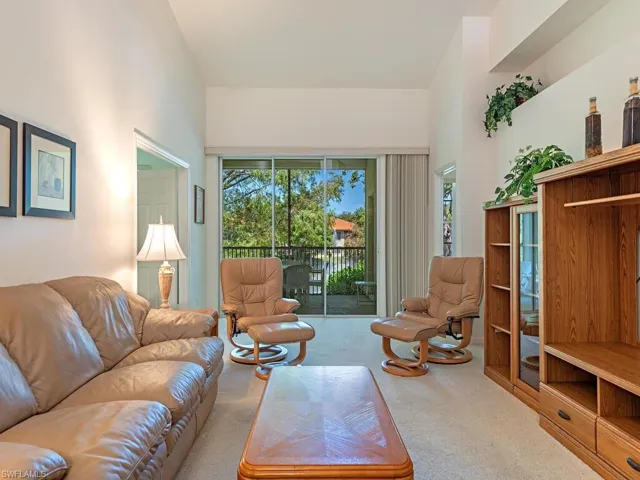 Living area featuring a high ceiling and carpet