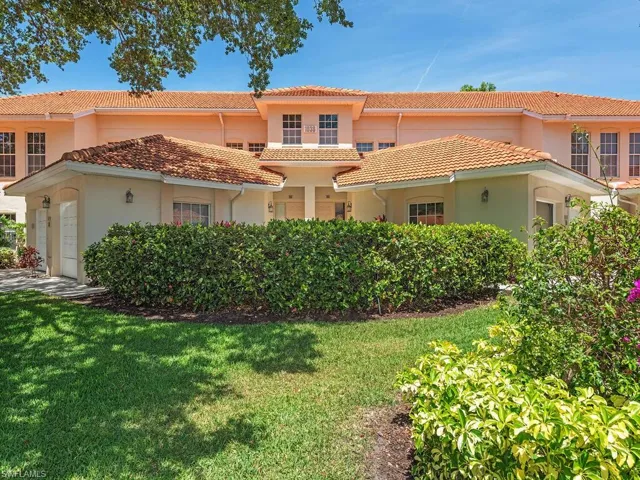 View of front of house with a tiled roof, an attached garage, a front yard, and stucco siding