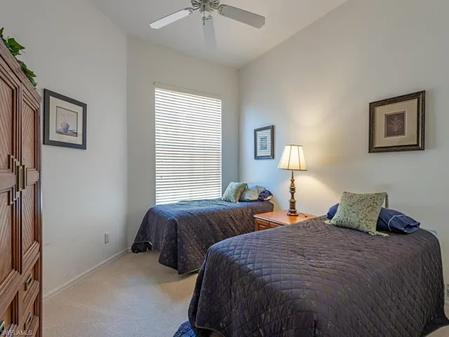 Carpeted bedroom featuring baseboards and ceiling fan