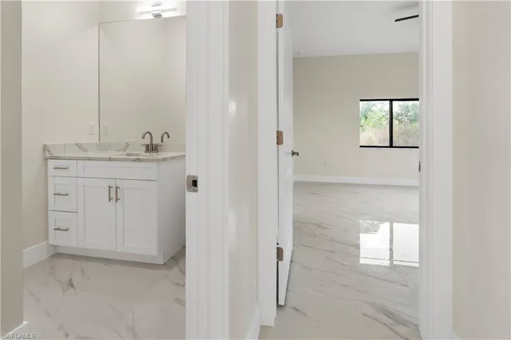Bathroom featuring light marble finish flooring and vanity