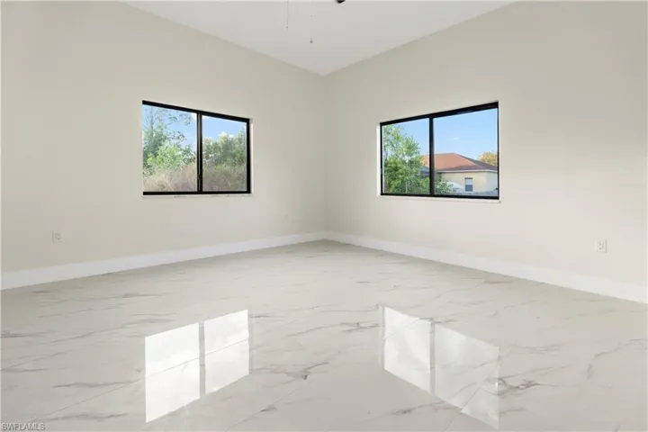Unfurnished room featuring light marble finish floors and plenty of natural light