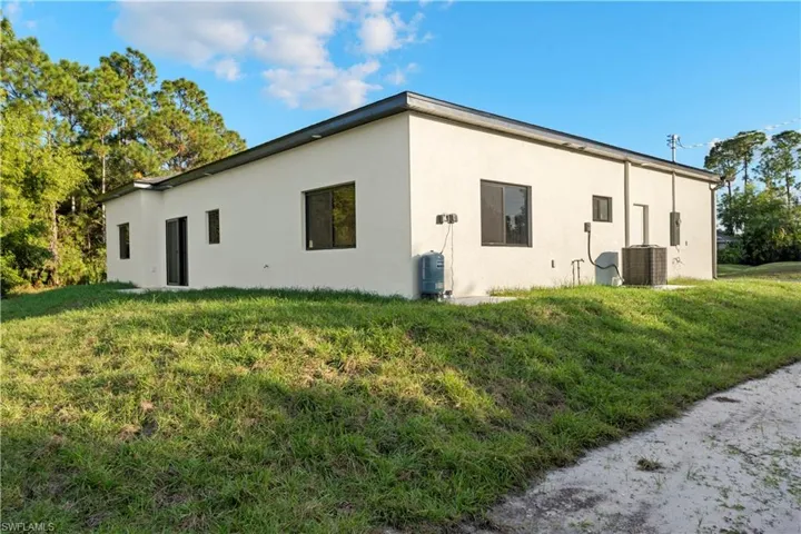 View of side of home featuring a yard and stucco siding