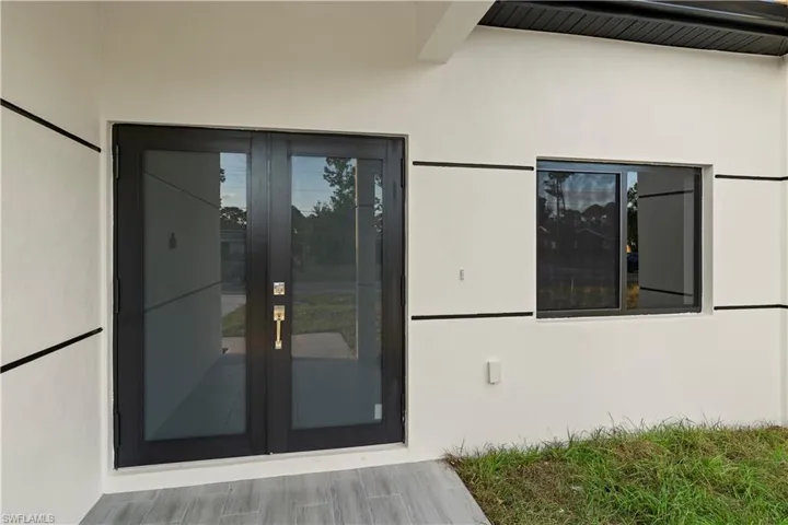 View of exterior entry with french doors and stucco siding