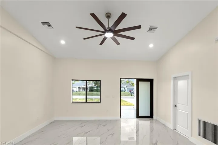 Unfurnished room featuring light marble finish flooring, ceiling fan, lofted ceiling, and recessed lighting