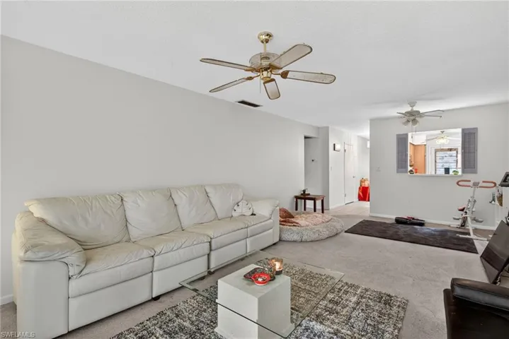 Living room featuring a ceiling fan and carpet flooring
