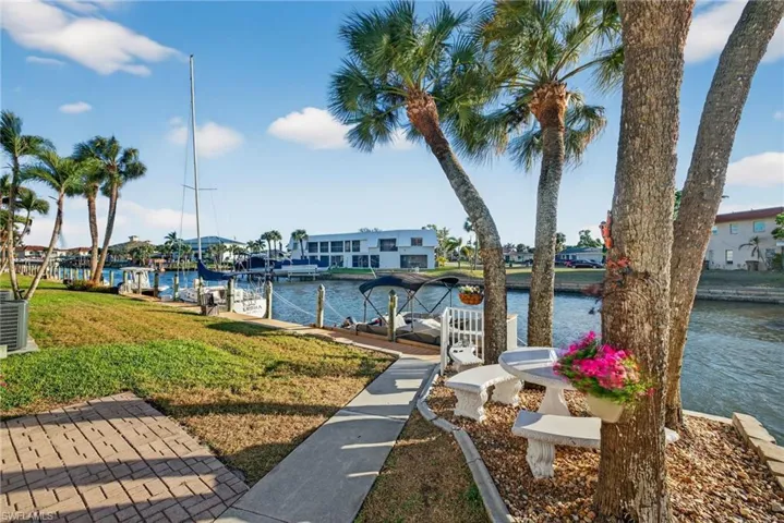 Dock area with a water view, boat lift, and a residential view