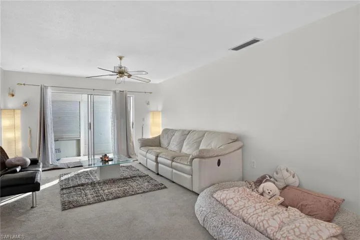 Carpeted living room featuring ceiling fan
