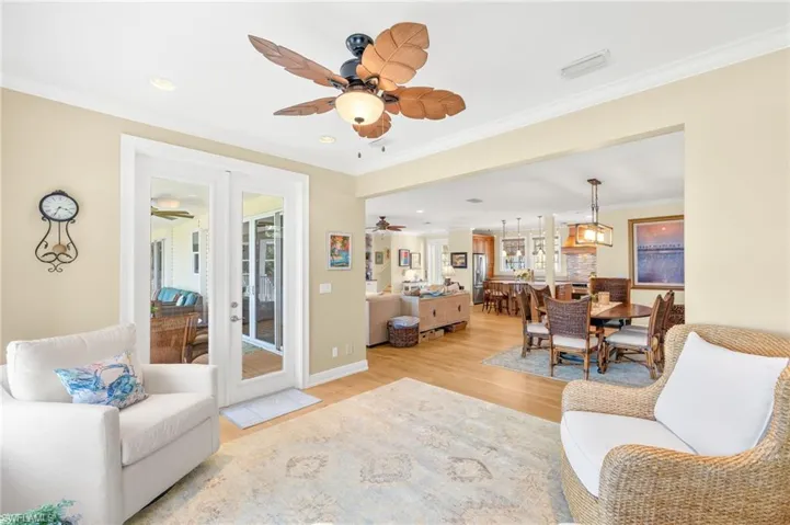 Living room featuring light wood-style flooring, crown molding, and recessed lighting