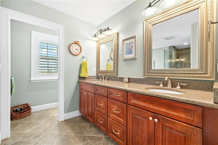 Full bathroom with double vanity and dark tile patterned floors