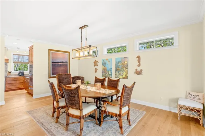 Dining room with ornamental molding and light wood finished floors