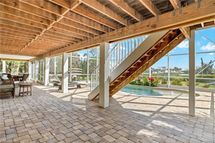 View of patio / terrace with stairway, a lanai, an outdoor pool, and outdoor dining space