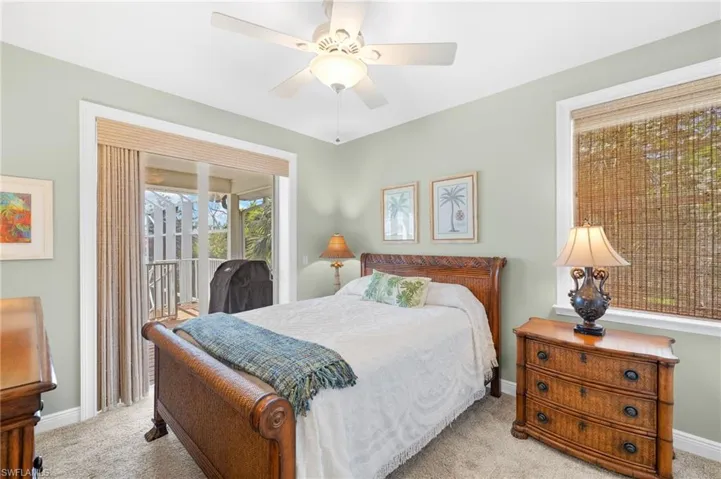 Carpeted bedroom featuring access to outside and ceiling fan