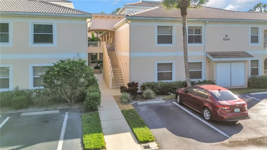 View of building exterior featuring stairs and parking Spot